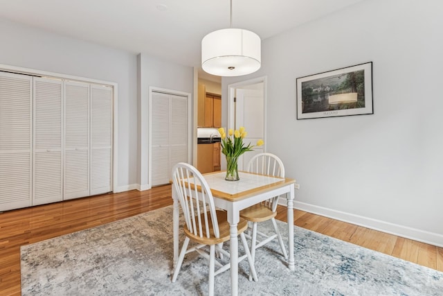 dining area featuring baseboards and light wood-type flooring