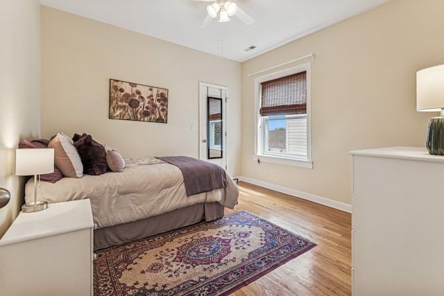 bedroom with a ceiling fan, baseboards, visible vents, and light wood-style floors