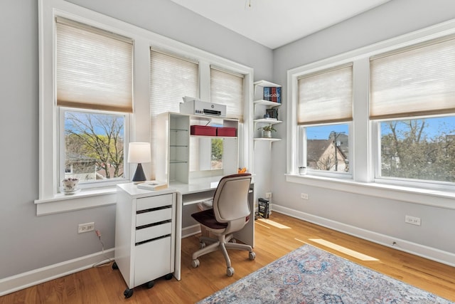 office area featuring a healthy amount of sunlight, baseboards, and wood finished floors