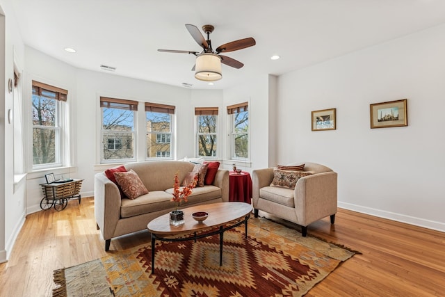 living area with light wood-style floors, baseboards, a ceiling fan, and recessed lighting