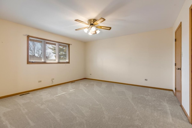 spare room with baseboards, visible vents, light colored carpet, and ceiling fan