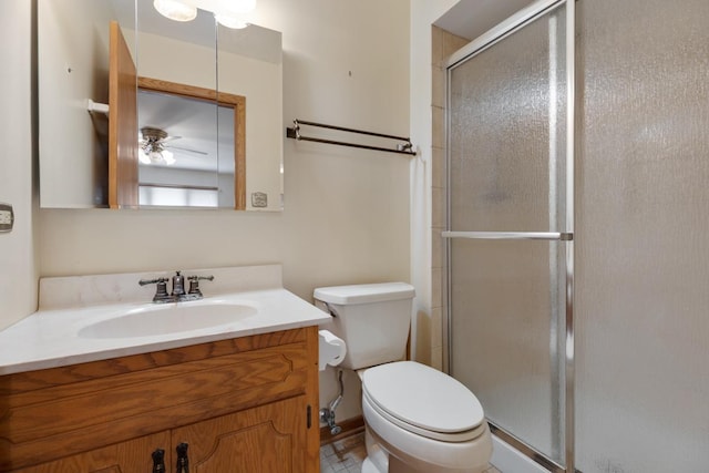 bathroom featuring vanity, a shower stall, and toilet