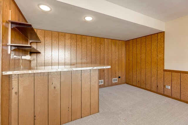 interior space featuring recessed lighting, visible vents, wood walls, and light colored carpet
