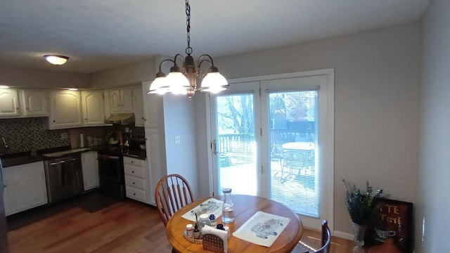 dining area with wood finished floors and an inviting chandelier