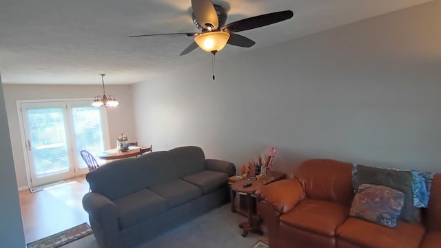 living room featuring ceiling fan with notable chandelier