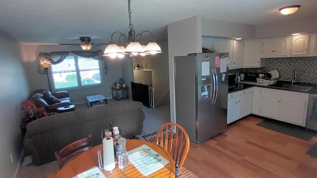 dining space with ceiling fan and light wood-style flooring