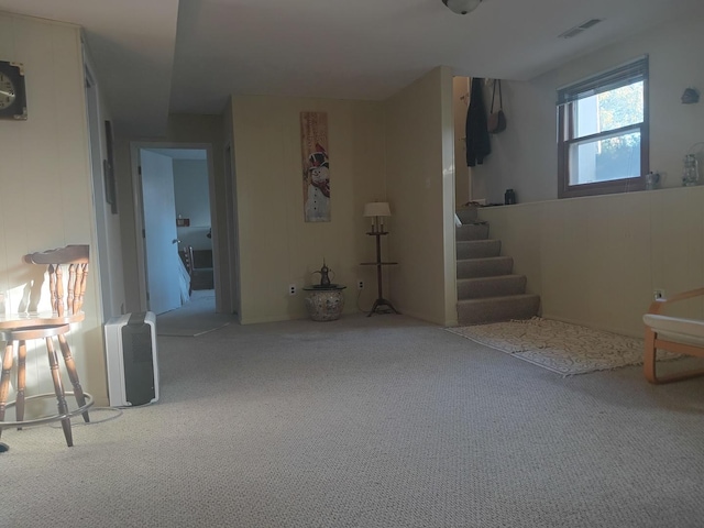 below grade area featuring stairway, carpet floors, and visible vents