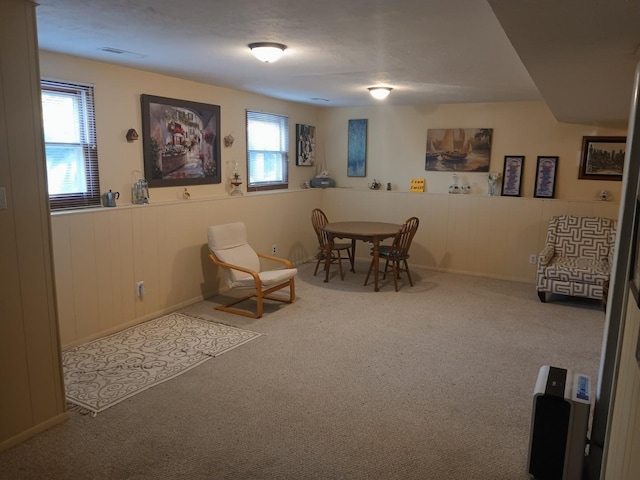 dining space featuring a wainscoted wall and carpet floors
