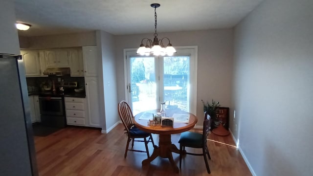 dining space featuring a chandelier, light wood-type flooring, and baseboards