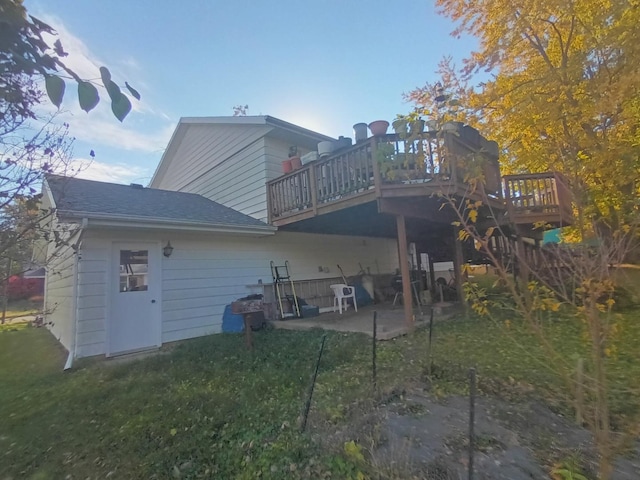 back of house featuring a patio area, roof with shingles, a yard, and a deck