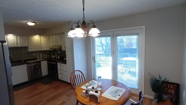 dining room featuring a wealth of natural light, a notable chandelier, and dark wood-type flooring