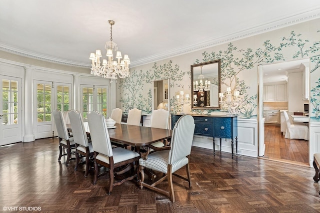 dining space with a decorative wall, a notable chandelier, a wainscoted wall, and crown molding