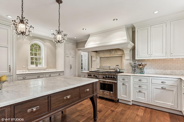 kitchen with decorative backsplash, stainless steel range, an inviting chandelier, premium range hood, and ornamental molding