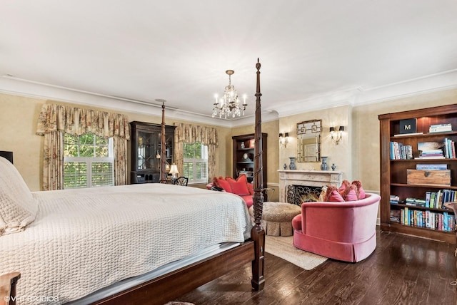 bedroom with wood finished floors, a fireplace, a notable chandelier, and ornamental molding