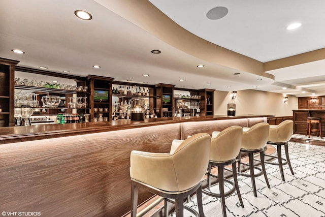 bar featuring recessed lighting, ornamental molding, a wainscoted wall, and a community bar