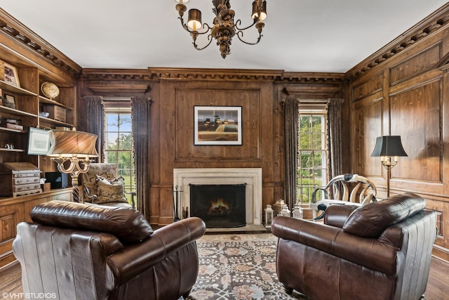 living area featuring wood finished floors, wood walls, and an inviting chandelier