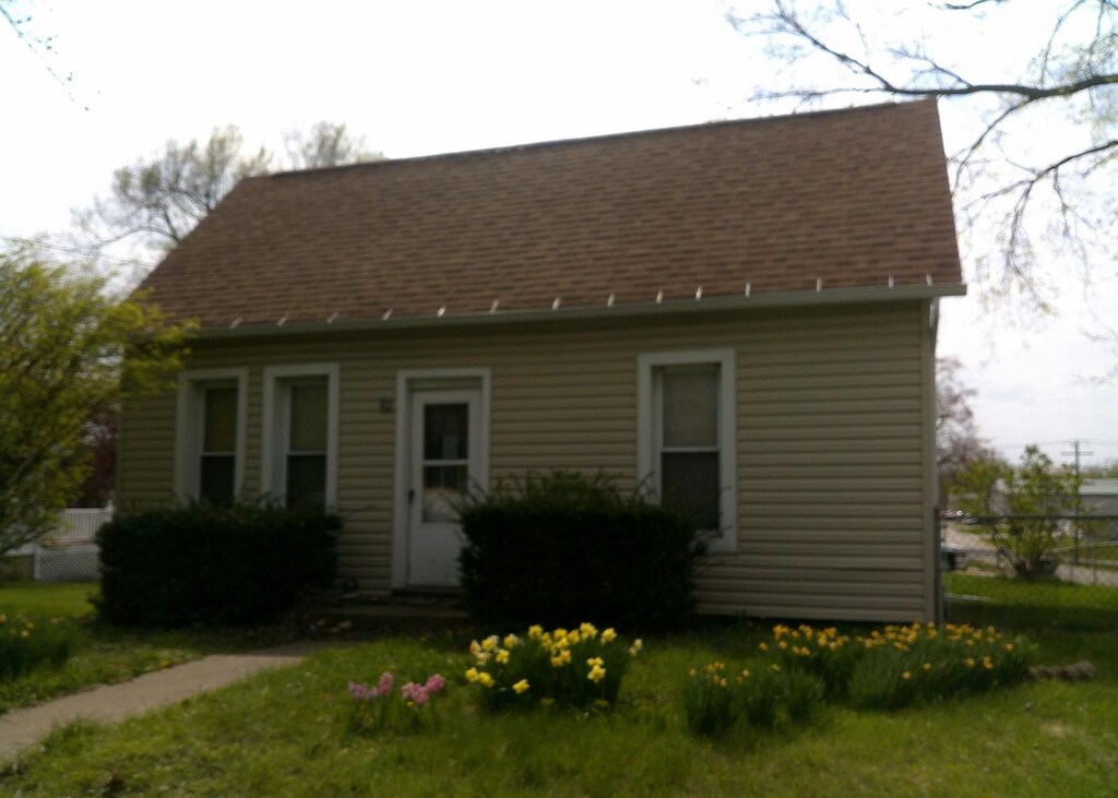 701 S Cain St, Clinton, IL 61727 - cape cod-style house with a shingled roof and a front lawn