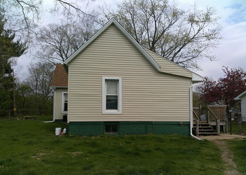 701 S Cain St, Clinton, IL 61727 - view of property exterior featuring a yard, fence, and a deck