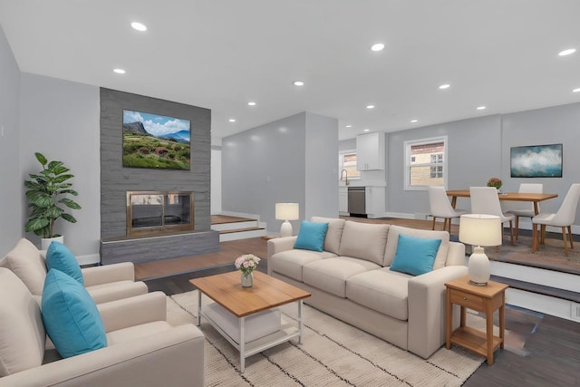 living area with a fireplace, recessed lighting, baseboards, and light wood-type flooring