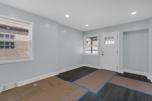 foyer with baseboards, visible vents, recessed lighting, and dark wood finished floors