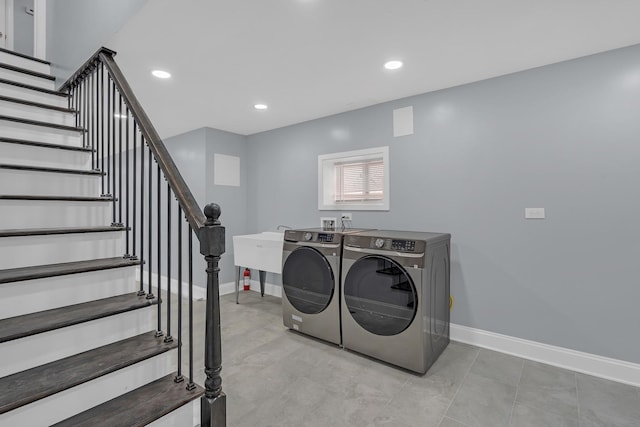 washroom with recessed lighting, washing machine and clothes dryer, and baseboards
