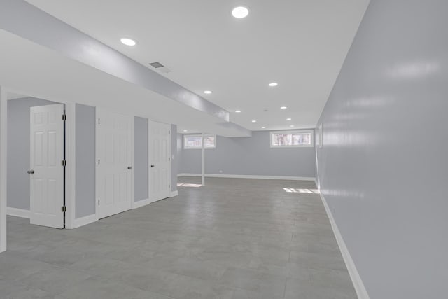 basement with baseboards, visible vents, and recessed lighting
