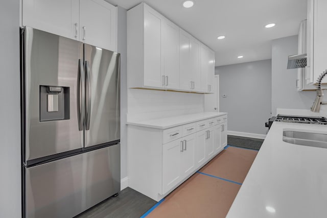 kitchen with stainless steel fridge, baseboards, recessed lighting, white cabinetry, and light countertops