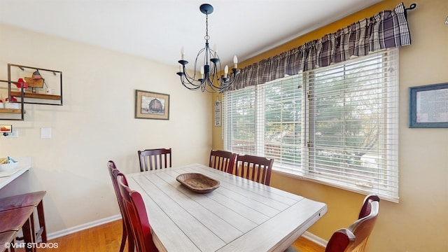 dining room with baseboards, wood finished floors, and a chandelier