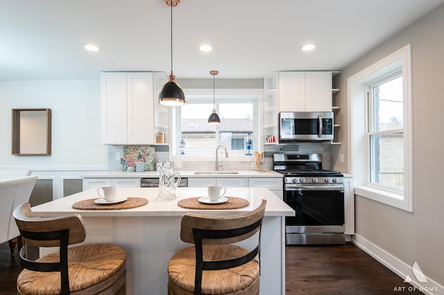 9106 S Eggleston Ave, Chicago, IL 60620 - kitchen featuring a kitchen breakfast bar, open shelves, a sink, stainless steel appliances, and light countertops