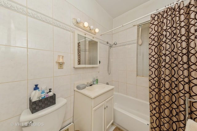 bathroom with toilet, tile walls, vanity, and shower / bath combo