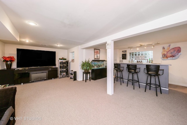 living area featuring carpet flooring and a dry bar