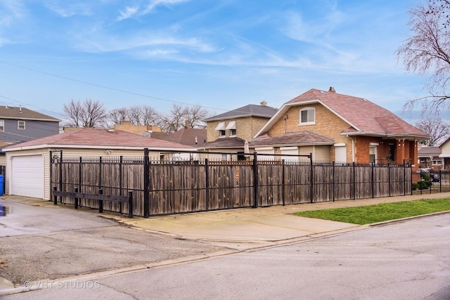 exterior space with brick siding, driveway, a garage, and a fenced front yard