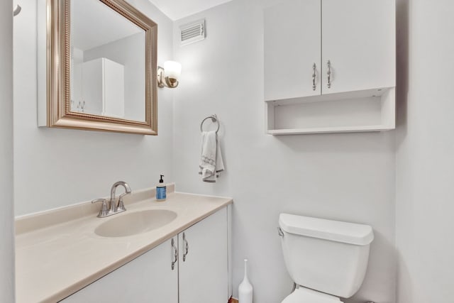 bathroom featuring vanity, toilet, and visible vents