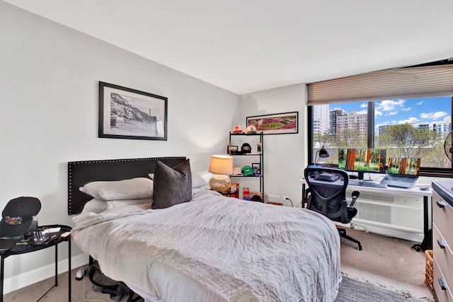 carpeted bedroom with a view of city and baseboards