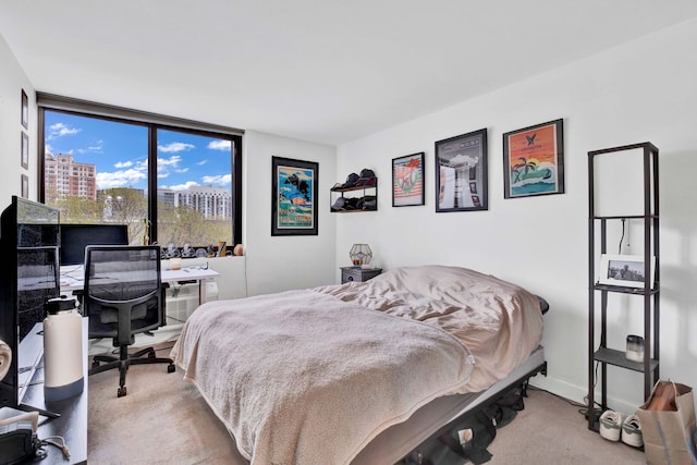 carpeted bedroom with expansive windows and baseboards