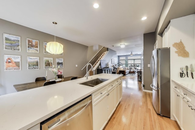 1705 W Le Moyne St Unit G, Chicago, IL 60622 - kitchen featuring stainless steel appliances, a sink, open floor plan, light countertops, and hanging light fixtures