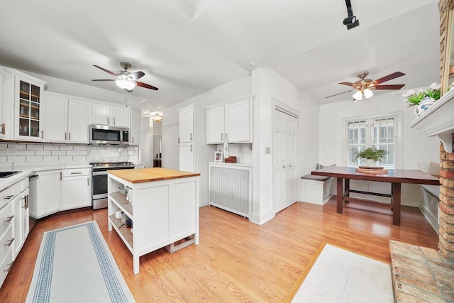 kitchen with white cabinetry, a ceiling fan, stainless steel appliances, and butcher block countertops