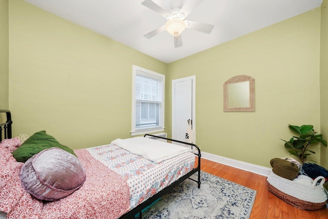 bedroom with ceiling fan, baseboards, and wood finished floors
