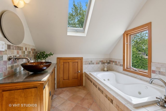 1515 W Glenlake Ave, Chicago, IL 60660 - full bathroom with vaulted ceiling, a tub with jets, vanity, a skylight, and decorative backsplash