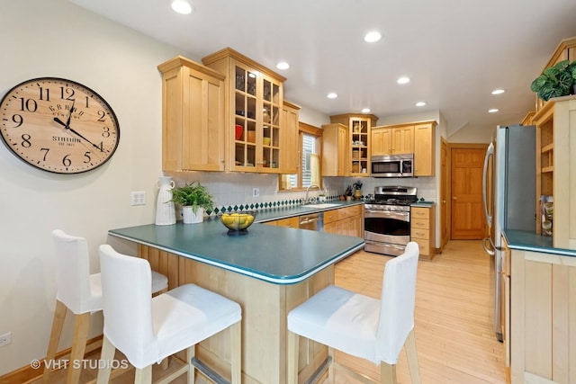 1515 W Glenlake Ave, Chicago, IL 60660 - kitchen featuring stainless steel appliances, a peninsula, recessed lighting, dark countertops, and light wood-style flooring