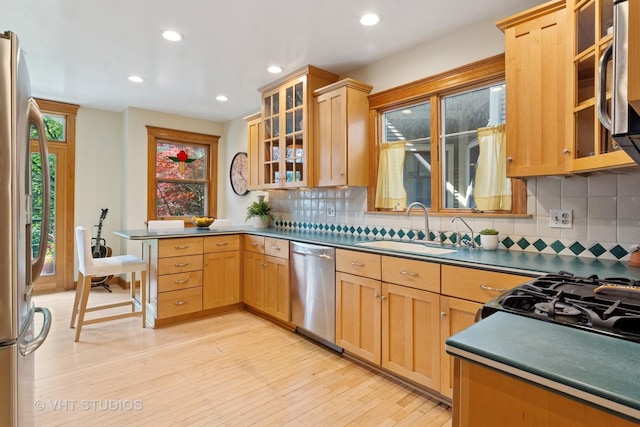 1515 W Glenlake Ave, Chicago, IL 60660 - kitchen featuring appliances with stainless steel finishes, backsplash, light wood finished floors, a peninsula, and recessed lighting