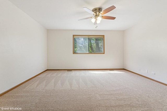 spare room featuring light carpet, baseboards, and ceiling fan