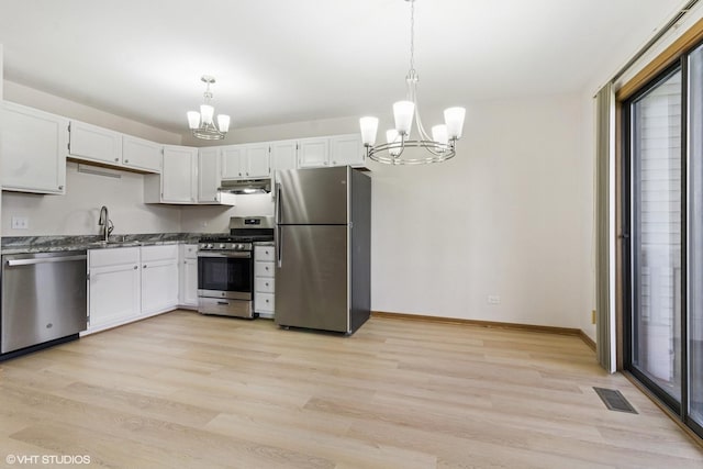 kitchen with appliances with stainless steel finishes, a chandelier, light wood-style floors, under cabinet range hood, and baseboards