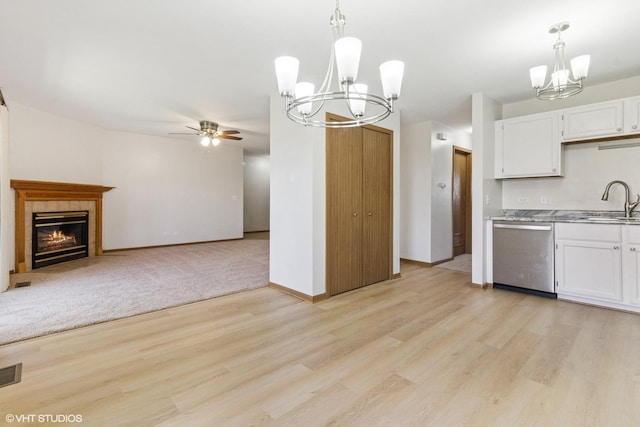 kitchen with stainless steel dishwasher, a chandelier, ceiling fan, light wood-style floors, and white cabinets