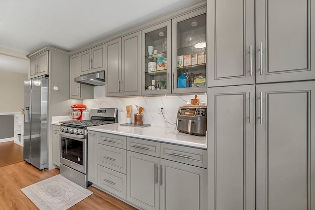218 Oak Knoll Ct Unit D1, Schaumburg, IL 60193 - kitchen with stainless steel appliances, gray cabinets, under cabinet range hood, light wood-style floors, and glass insert cabinets