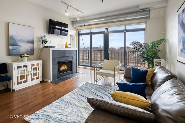living room with track lighting, a fireplace, french doors, and wood finished floors