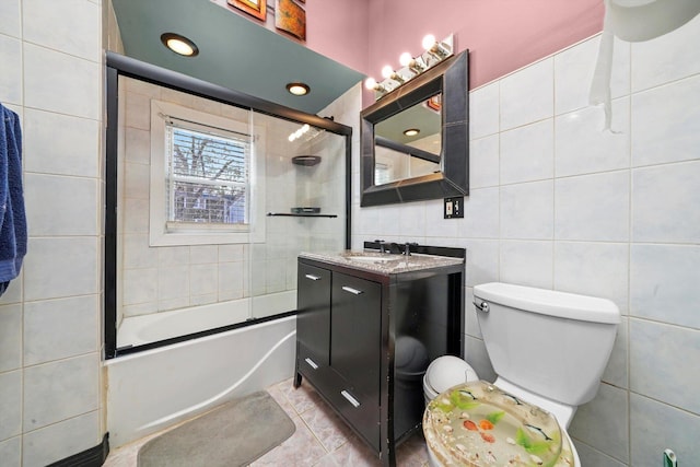 3024 E Ave, Berwyn, IL 60402 - bathroom featuring combined bath / shower with glass door, vanity, tile walls, toilet, and tile patterned flooring