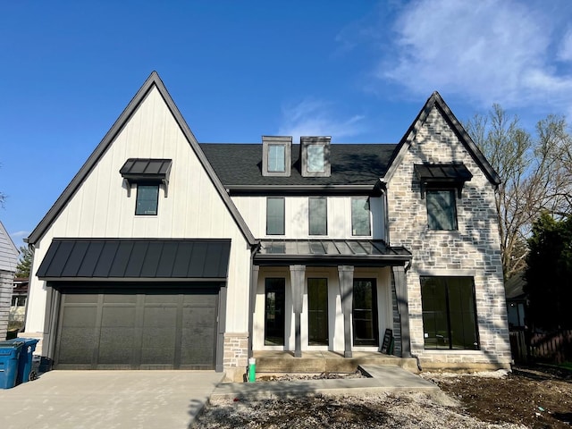 view of front of property with roof with shingles, a standing seam roof, stone siding, concrete driveway, and metal roof