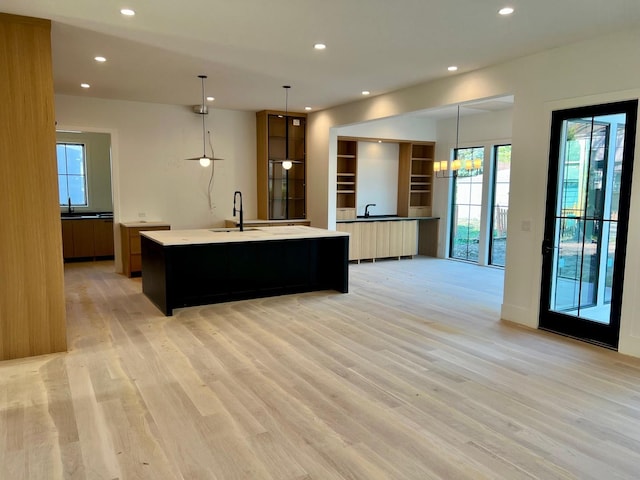 kitchen featuring modern cabinets, recessed lighting, light wood-style floors, and a spacious island