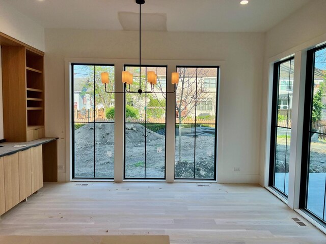 unfurnished dining area featuring recessed lighting, visible vents, light wood finished floors, and an inviting chandelier